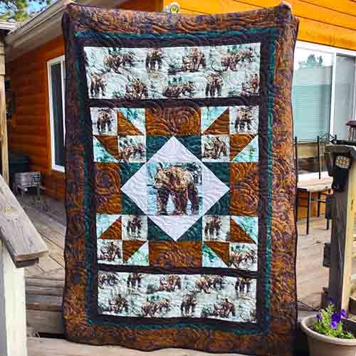 A twin size quilt with a bear panel and fabric depicting bears in a oversized star block.