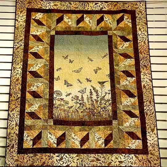 A beautiful panel quilt with butterflies and flowers done in a monotone brown gold color.