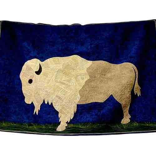 A bison appliqued on dark blue background with a dark green for grass.