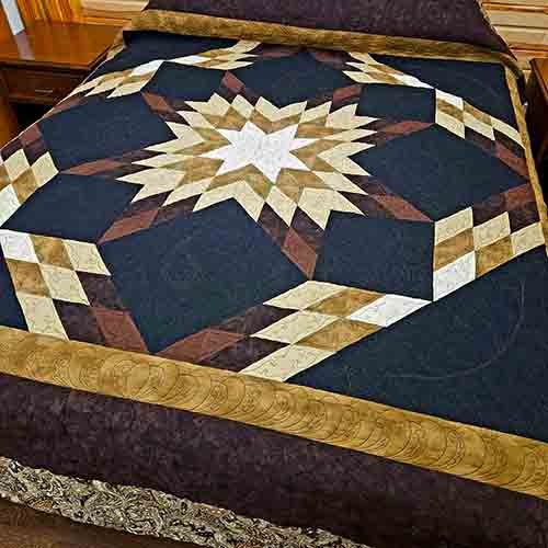 A lone star quilt in browns and cream color with a white star center.